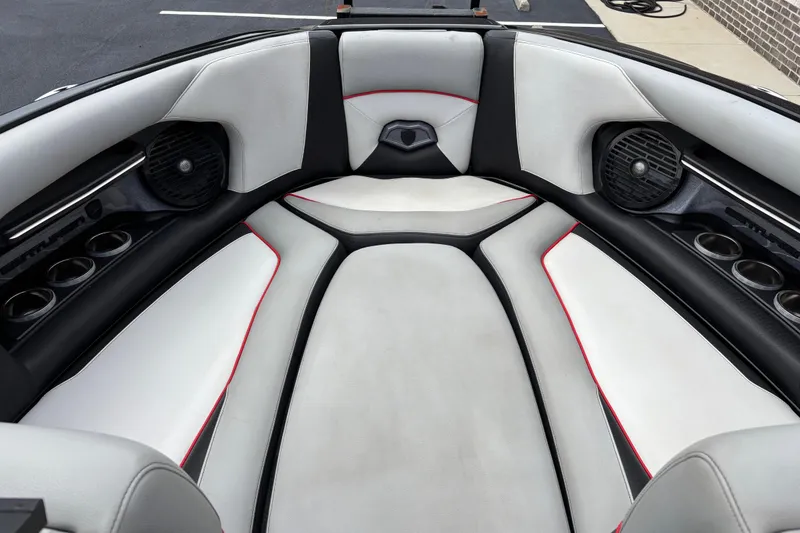 Slide: The Image of 2018 Centurion Ri257 boat interior with white and black seating, cup holders, and speakers. - 6