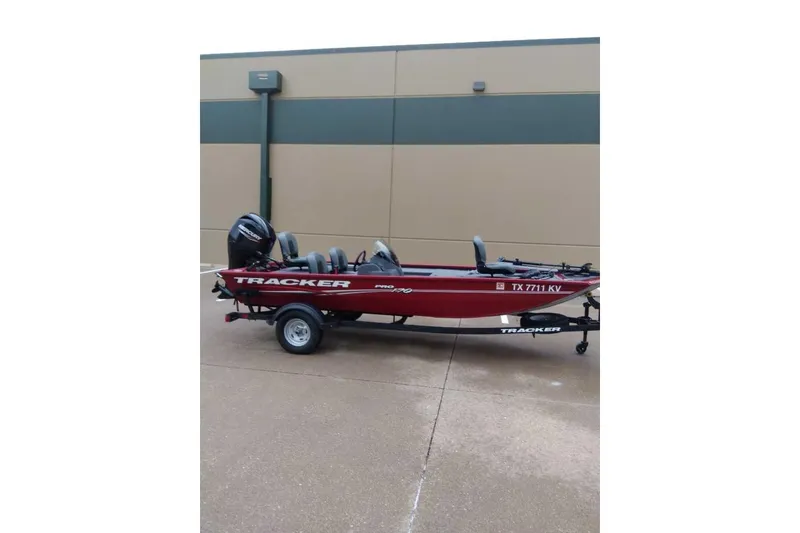 Slide: The Image of 2024 Bass Tracker Pro 170 boat on trailer, parked against a beige wall. - 7