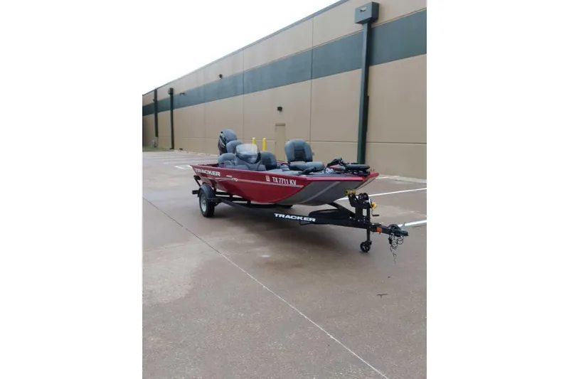 Slide: The Image of 2024 Bass Tracker Pro 170 boat on trailer, parked in an industrial area. - 8