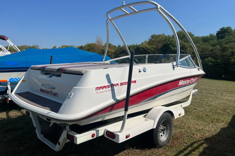 Slide: The Image of 1996 MasterCraft MariStar 210 VRS boat on trailer, parked on grass under clear sky. - 3