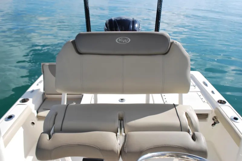 Slide: The Image of 2021 Key West 210 Bay Reef boat interior with beige seating on calm water. - 16