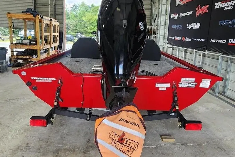 Slide: The Image of 2025 Tracker Pro Team 175 boat in a garage, featuring a red exterior and outboard motor. - 4