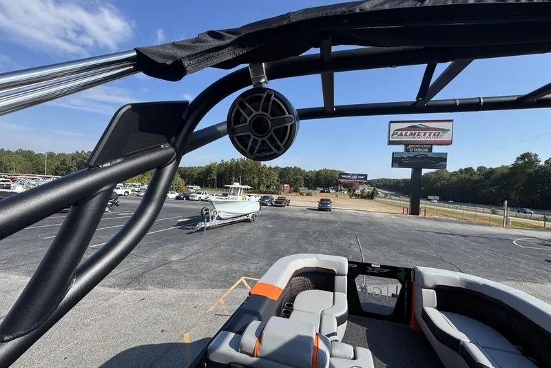 Slide: The Image of 2026 Godfrey XP 2700 TWIN boat interior with speaker, parked in a lot under clear sky. - 26