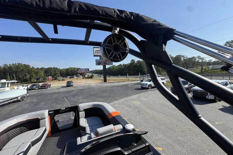 Slide: The Image of 2026 Godfrey XP 2700 TWIN boat interior with seating and speaker, parked in a lot. - 27