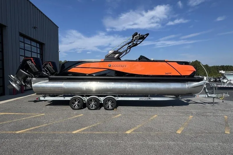 Slide: The Image of 2026 Godfrey XP 2700 TWIN pontoon boat on trailer, vibrant orange design, dual engines. - 5