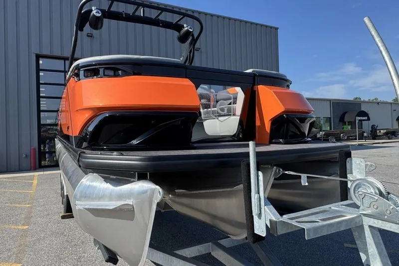 Slide: The Image of 2026 Godfrey XP 2700 TWIN pontoon boat with vibrant orange accents on a trailer. - 6