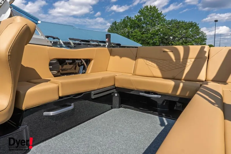 Slide: The Image of 2026 MasterCraft NXT22 boat interior with tan leather seating under a blue sky. - 10