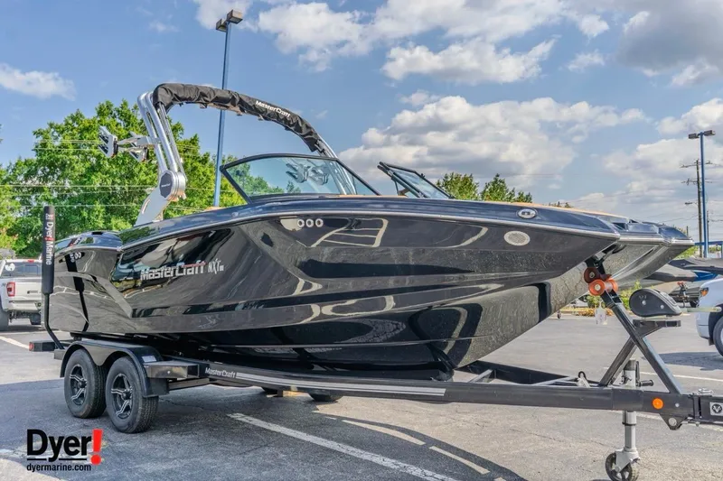 Slide: The Image of 2026 MasterCraft NXT22 boat on trailer, sleek black design, parked outdoors. - 7