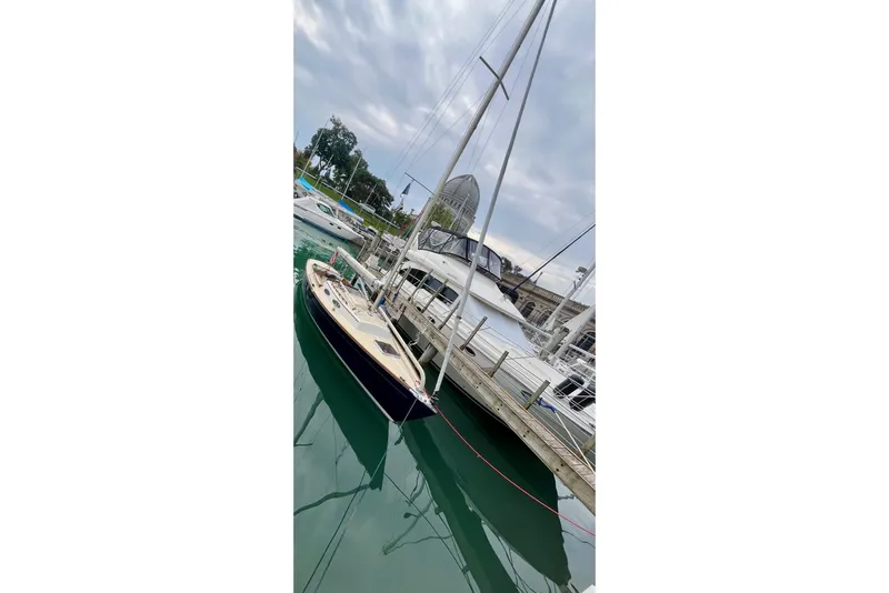 Slide: The Image of Sailboat Alerion Express 28, 2012 model, docked at a marina under cloudy skies. - 5