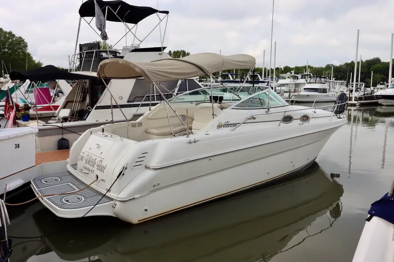 The Image of 2000 Sea Ray 270 Sundancer docked at marina, featuring beige canopy and sleek design. - 0