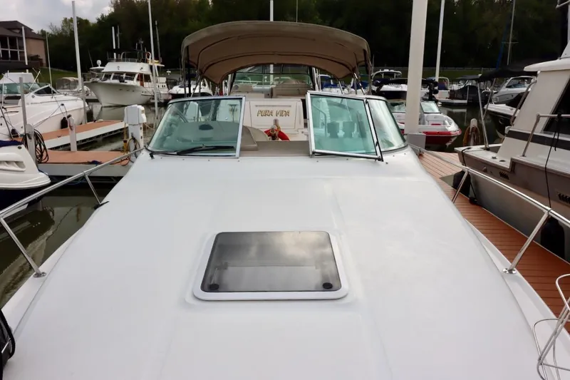 Slide: The Image of 2000 Sea Ray 270 Sundancer docked at marina, featuring spacious deck and windshield. - 13