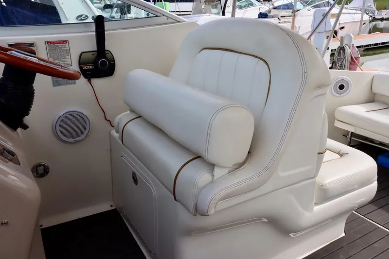 Slide: The Image of Captain's seat on 2000 Sea Ray 270 Sundancer boat, featuring white upholstery and dashboard controls. - 15