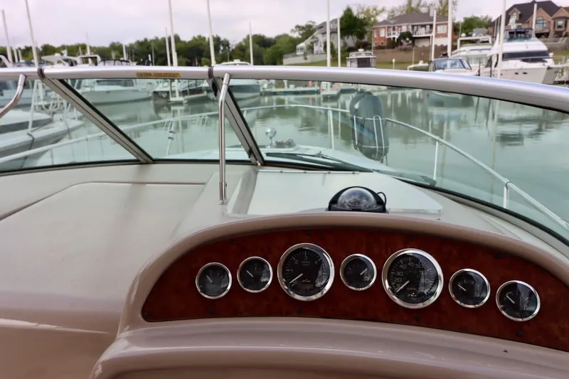 Slide: The Image of 2000 Sea Ray 270 Sundancer dashboard with gauges, docked in a marina. - 18