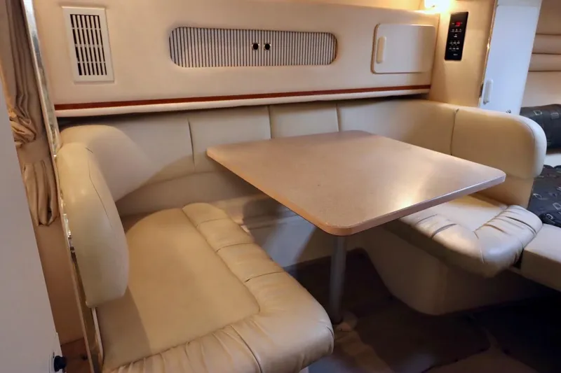 Slide: The Image of Interior of 2000 Sea Ray 270 Sundancer with beige seating and dining table. - 22