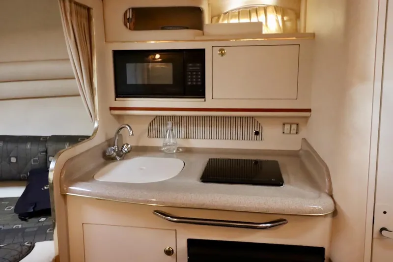 Slide: The Image of Compact kitchen area in a 2000 Sea Ray 270 Sundancer boat with sink and microwave. - 24