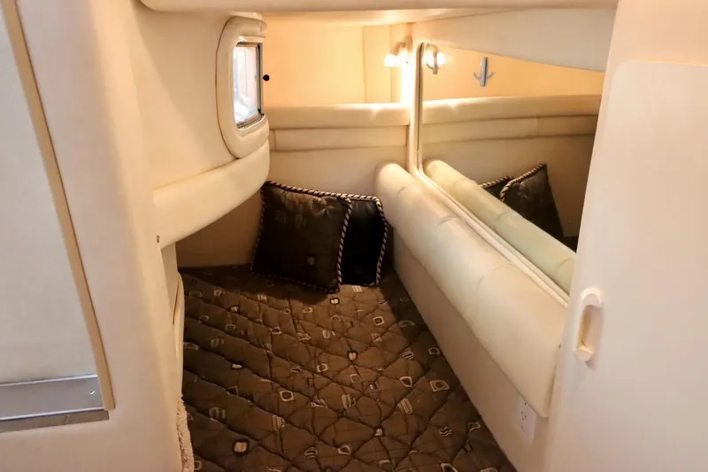 Slide: The Image of Interior cabin of 2000 Sea Ray 270 Sundancer with cozy bedding and window. - 26