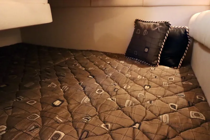 Slide: The Image of Interior cabin of 2000 Sea Ray 270 Sundancer with patterned bedding and pillows. - 27