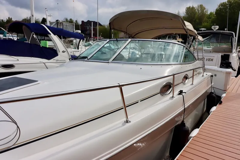 Slide: The Image of 2000 Sea Ray 270 Sundancer docked at marina, featuring sleek design and canopy. - 3