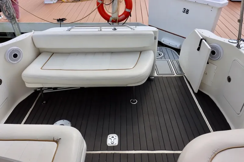 Slide: The Image of Interior of 2000 Sea Ray 270 Sundancer boat with white seating and dark flooring. - 8