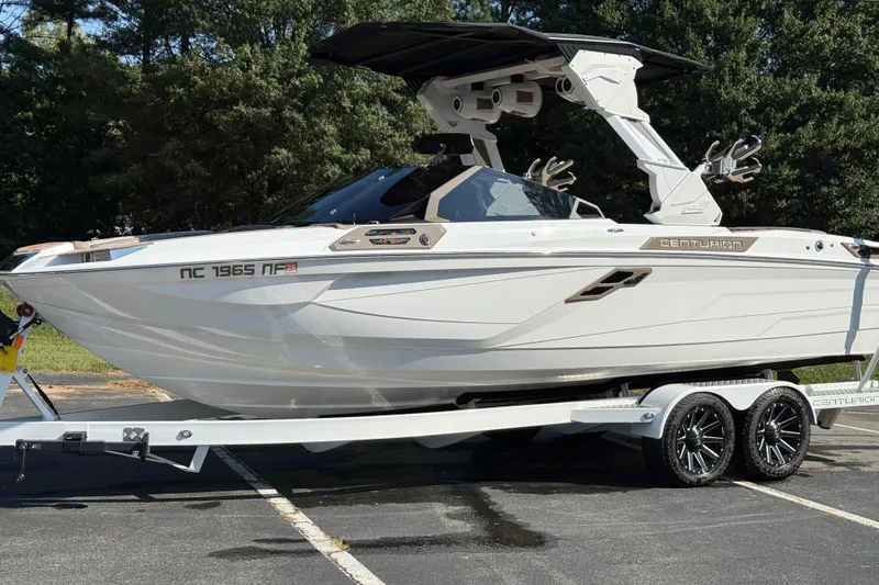 Slide: The Image of 2025 Centurion Ri245 boat on trailer, parked outdoors, showcasing sleek design and modern features. - 8