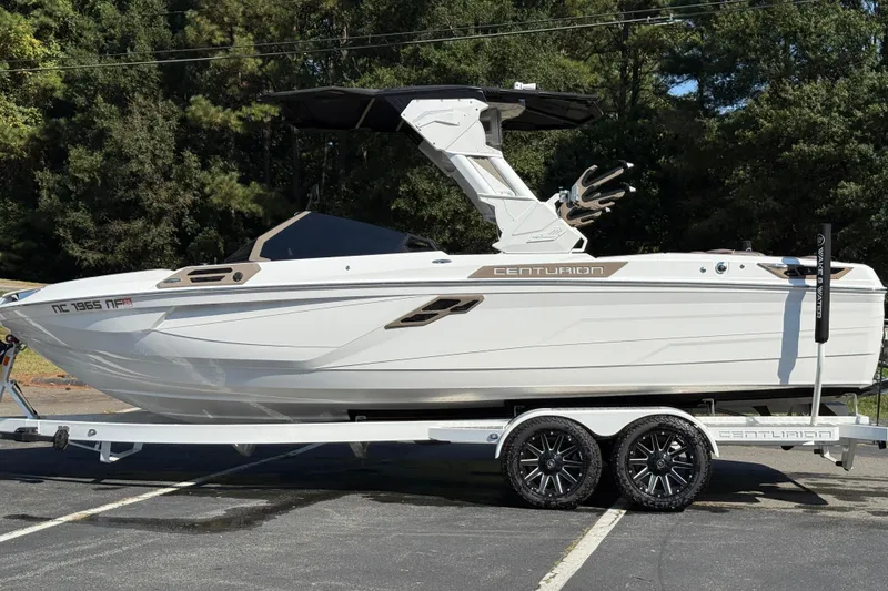 Slide: The Image of 2025 Centurion Ri245 boat on trailer, parked outdoors, showcasing sleek design and modern features. - 9
