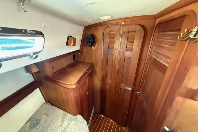 Slide: The Image of 1997 Island Packet 37 sailboat interior with wooden cabinetry and cozy sleeping area. - 10