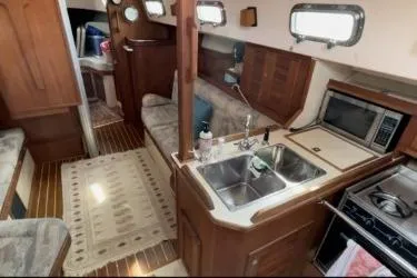 Slide: The Image of Interior of a 1997 Island Packet 37 sailboat with kitchen and seating area. - 11