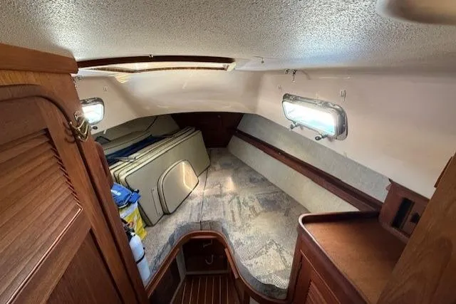 Slide: The Image of Interior cabin of 1997 Island Packet 37 sailboat with wooden accents and storage space. - 4