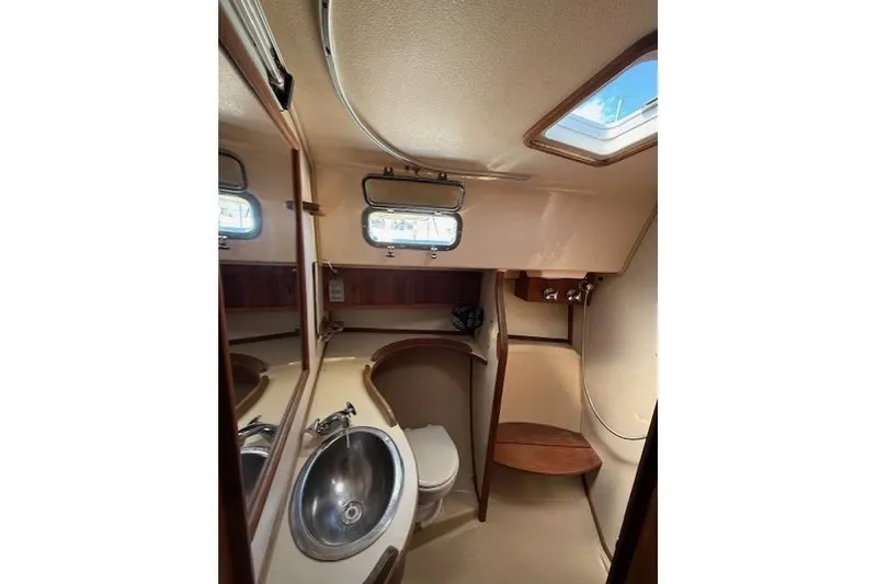 Slide: The Image of 1997 Island Packet 37 yacht bathroom with sink, toilet, and wooden accents. - 6