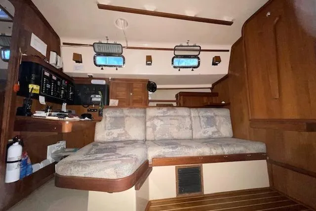 Slide: The Image of Interior of a 1997 Island Packet 37 sailboat with cozy seating and wooden accents. - 7