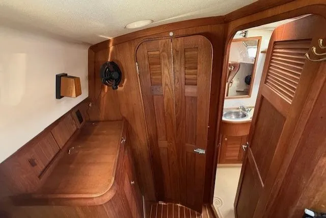 Slide: The Image of Interior of 1997 Island Packet 37 sailboat with wooden cabinetry and bathroom view. - 9