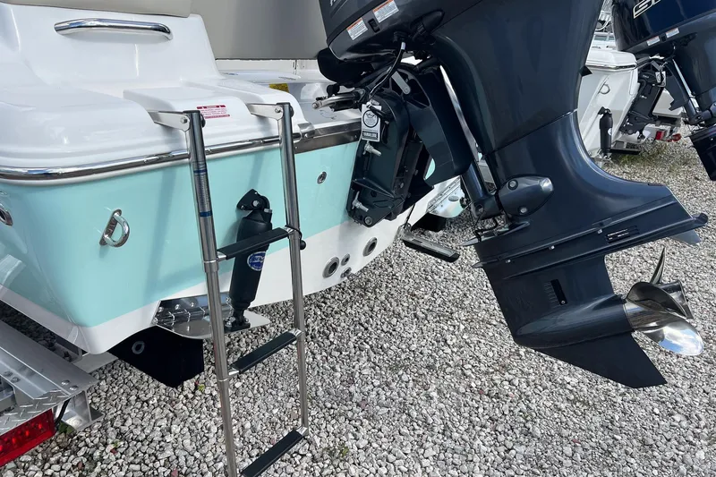 Slide: The Image of 2026 Key West 189 FS boat with outboard motor and swim ladder on gravel. - 6