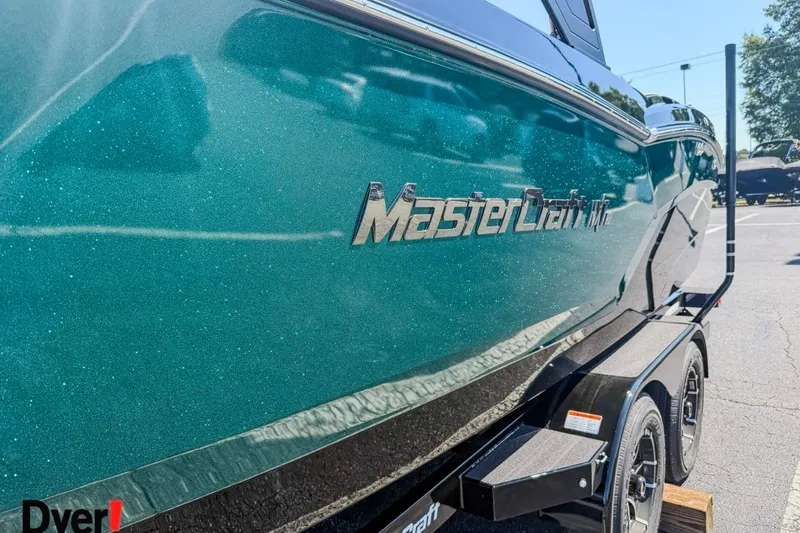 Slide: The Image of 2026 MasterCraft NXT23 boat with metallic teal finish on a trailer. - 4
