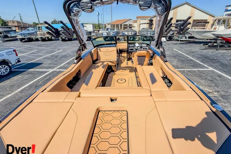 Slide: The Image of 2026 MasterCraft NXT23 boat interior with tan seating and modern design in a dealership lot. - 6