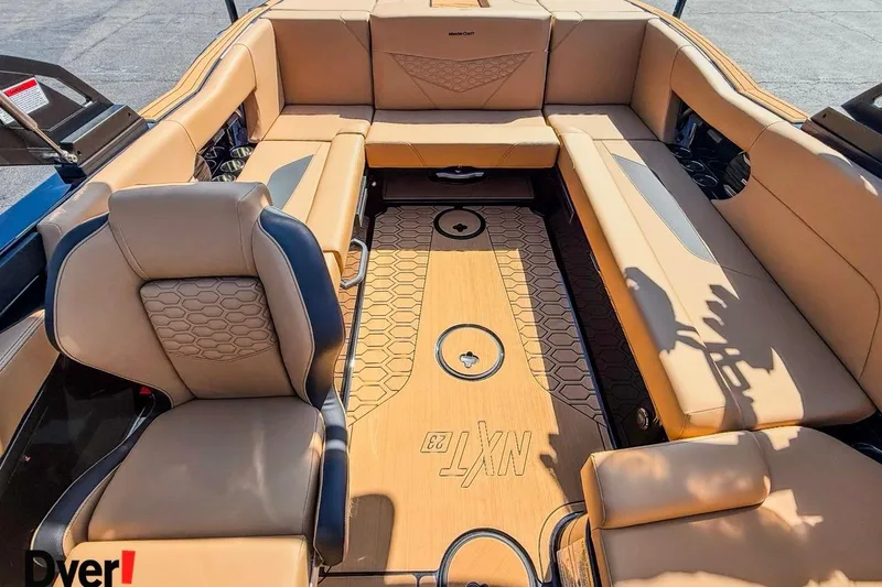 Slide: The Image of 2026 MasterCraft NXT23 boat interior with tan seating and stylish flooring design. - 7