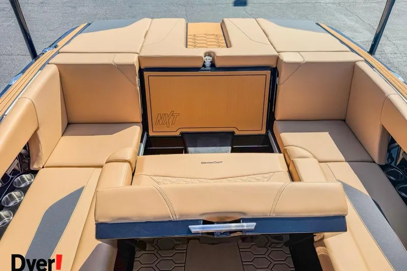 Slide: The Image of 2026 MasterCraft NXT23 boat interior with tan seating and cup holders. - 8