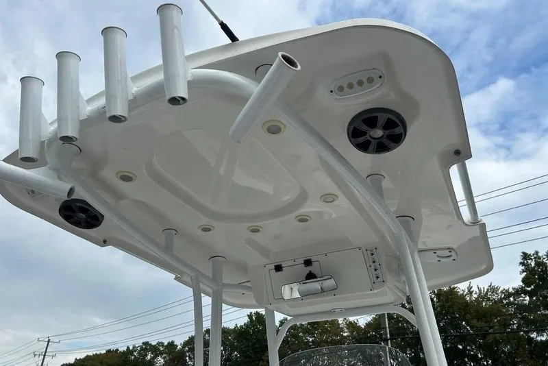 Slide: The Image of 2019 Sea Pro 219 boat T-top with rod holders and speakers against a cloudy sky. - 11