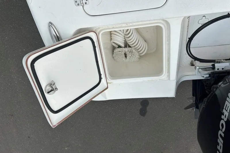 Slide: The Image of Open storage compartment on 2019 Sea Pro 219 boat with hose and brush inside. - 20