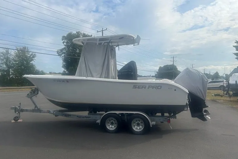 Slide: The Image of 2019 Sea Pro 219 boat on trailer, parked outdoors under cloudy sky. - 28