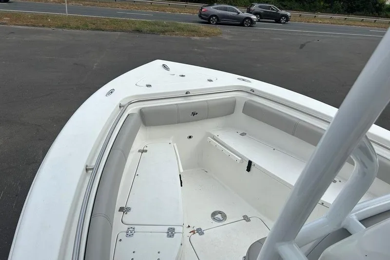 Slide: The Image of 2019 Sea Pro 219 boat interior with seating and storage, parked near a road. - 29
