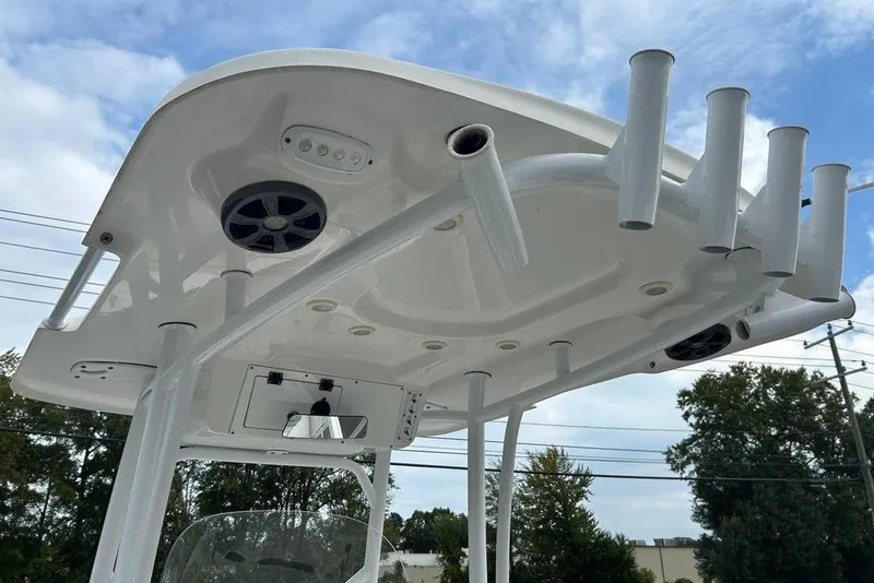Slide: The Image of 2019 Sea Pro 219 boat T-top with rod holders and speakers against a cloudy sky. - 9