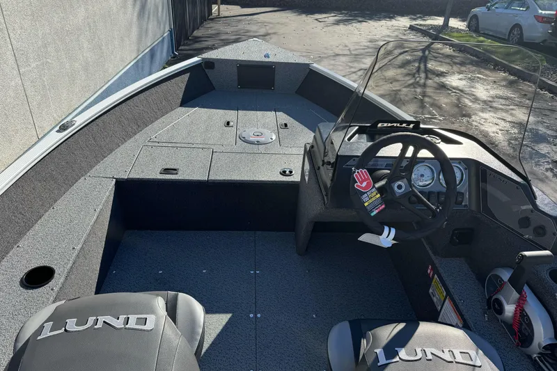 Slide: The Image of 2026 Lund 1650 Angler SS boat interior with steering console and seating. - 11
