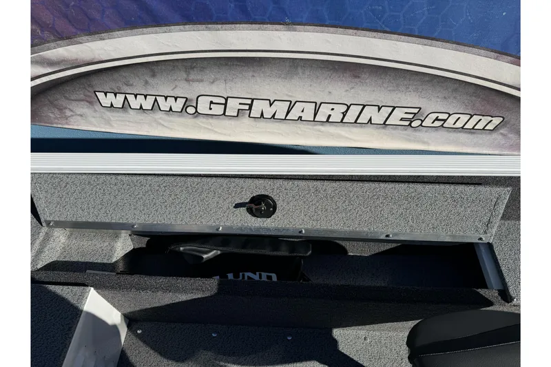Slide: The Image of 2026 Lund 1650 Angler SS boat interior with storage compartment and GFMarine.com branding. - 15