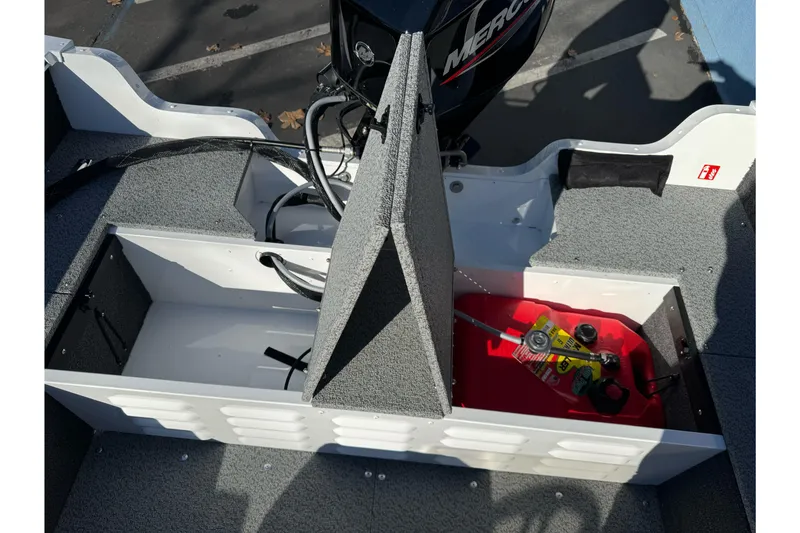 Slide: The Image of 2026 Lund 1650 Angler SS boat interior with storage compartments and Mercury engine. - 17