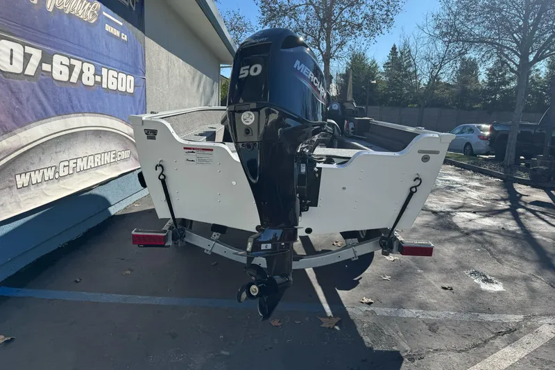 Slide: The Image of 2026 Lund 1650 Angler SS boat with Mercury 50 engine, parked outdoors. - 4