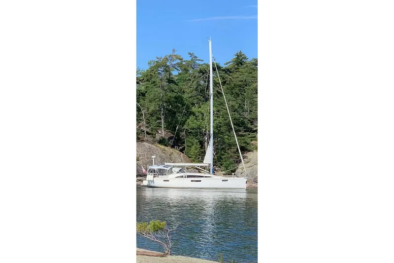 The Image of Sailboat Bavaria Vision 42, 2013 model, anchored near a forested shoreline. - 0