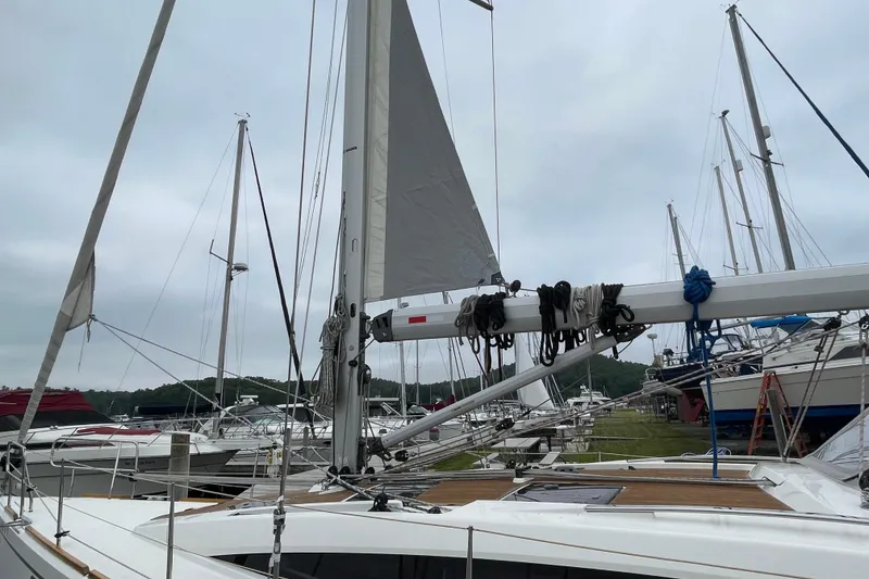 Slide: The Image of Sailboats docked at marina, featuring a 2013 Bavaria Vision 42 with raised sails. - 12