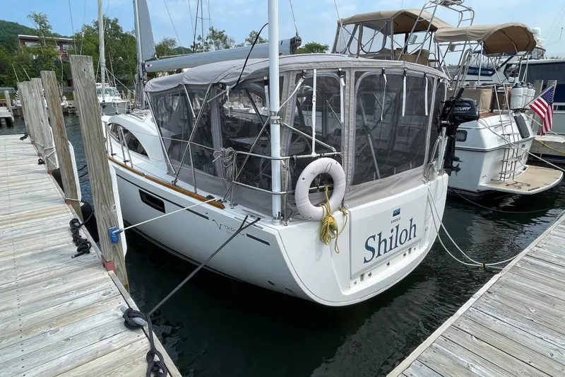 Slide: The Image of 2013 Bavaria Vision 42 sailboat docked, featuring enclosed cockpit and lifebuoy. - 2