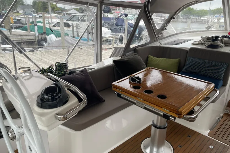 Slide: The Image of Bavaria Vision 42 yacht interior with wooden table and cushioned seating, docked at marina. - 28