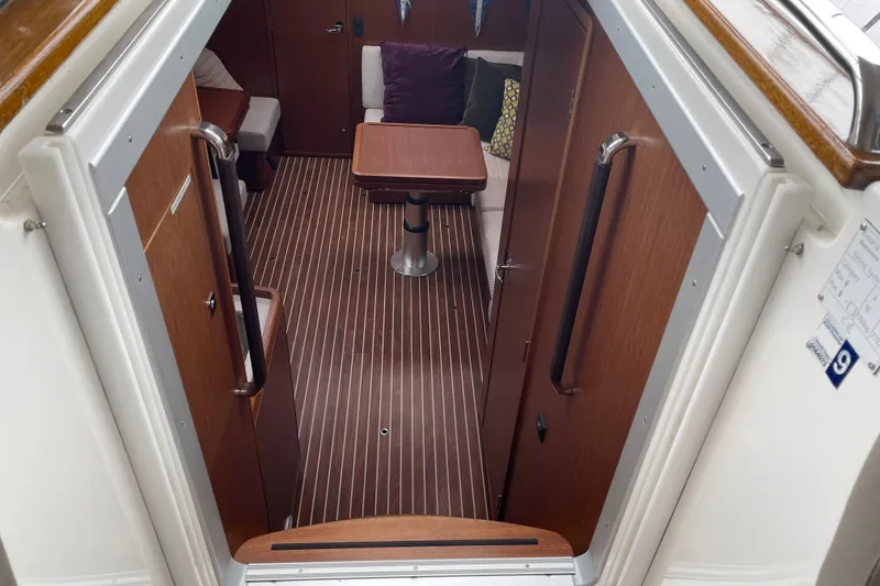 Slide: The Image of Interior view of 2013 Bavaria Vision 42 sailboat, featuring wood paneling and seating area. - 55